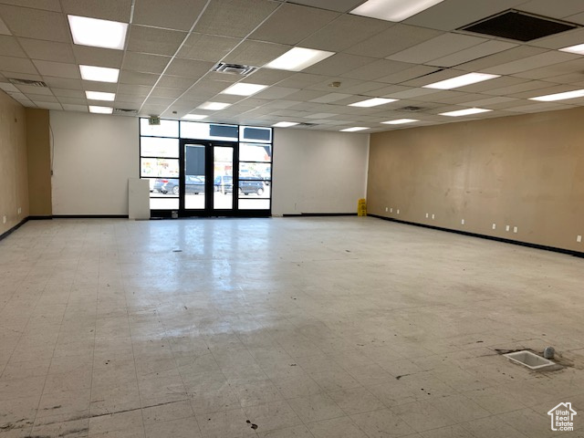 Empty room featuring baseboards and a drop ceiling