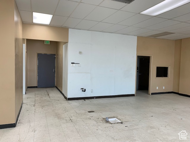 Empty room with a paneled ceiling and baseboards