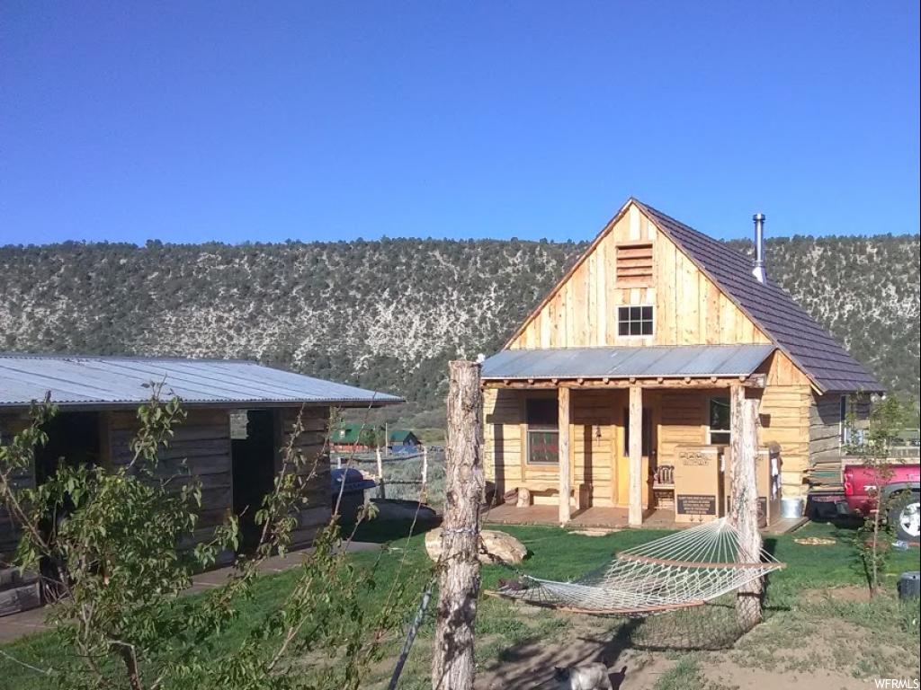 28700 11150 E N Fairview, Utah NEW LOWERED PRICE! Beautiful 3.5 acres with stunning panoramic views! Comes with cozy custom built log cabin built with hand hewn authentic pioneer logs. Master bed with 1/2 bath. 2nd bedroom has a small loft with a queen bed. Basement has a separate outside entrance and is used for storage only. It includes a lot of storage shelving and an 1100 gallon water tank. Has an amazing well with great tasting water and 16 fruit trees. Out buildings include a pioneer log barn, storage shed, and an additional 3 room log building. Comes with a large dog kennel and 2 fenced pastures. There is also an RV hookup. Bring your animals and your toys! Snowmobiling, 4-wheeling and horseback riding right on your own property with access to equestrian and other trails that access Skyline Dr/Manti National Forest. Square footage figures are provided as a courtesy estimate only and were obtained from sellers measurement. Buyer is advised to obtain an independent measurement. Agent is related to seller.