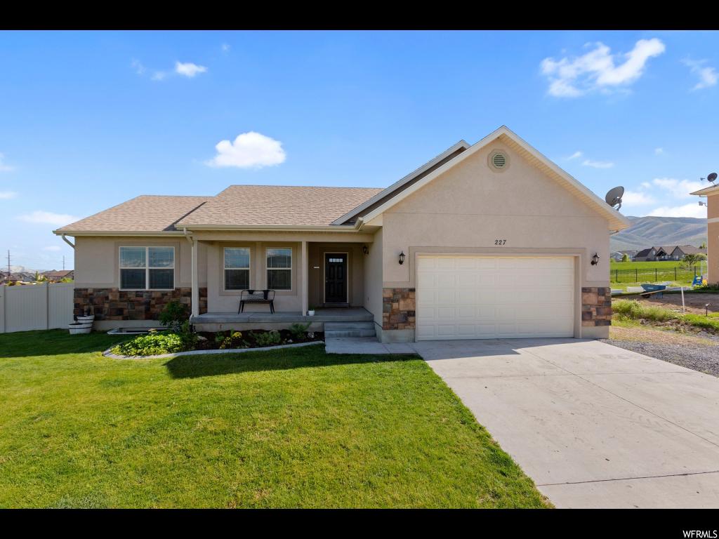 227 LARIAT BLVD Saratoga Springs, Utah Wonderful location, home sits on 1/3 acre corner lot with gorgeous views of the lake and mountains! No HOA! No backyard neighbors due to open park space. 5 minutes from new temple site! Upgrades throughout: 32 ft Trex deck, spacious floor plan, vaulted ceilings, 5 bedrooms, 2 bathrooms, 2-car garage, walk-in cold storage, wood-grain tile floors, quartz countertops, farm sink. Fully fenced-in, landscaped yard. Square footage provided is from a recent appraisal. Buyer to verify all information. Square footage figures are provided from former Appraisal available upon request. Buyer is advised to obtain an independent measurement.