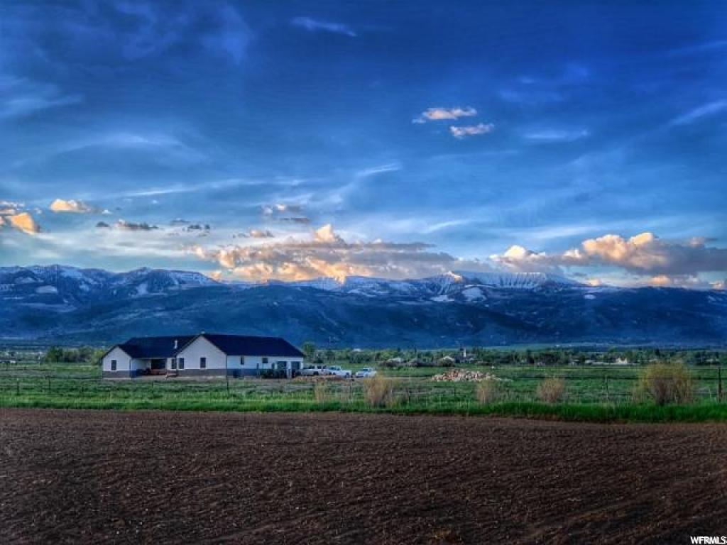 7355 15720 N E Spring City, Utah Brand NEW home with great room open floor plan and a large den and mudroom on a 38-acre horse/hay ranchette with well water, Rocky Mountain Power and 1,000 gal buried propane tank that you own for gas. Subdividable and it currently has 3 parcel numbers. Great views of the mountains from every window and the porches. 18 shares of Horseshoe irrigation and 1-acre-ft well water right. About 4 acres is pressurized with a hand line. 60 tons of hay on the 1st cutting. 2 new fields of 9 acres planted this spring should produce an additional 15 to 20 tons. New fields are pasture grass, excellent for horses. Other fields are alfalfa/grass mixture. 37 acres in green belt. Two water heaters, the basement is plumbed for a bath and you can frame the rest as you wish - 3 or 4 bedrooms would not be a problem, cold storage, built-in double size fridge and freezer, humidifier on furnace, intercom and garage has two separate single doors for more room. MLS map is correct. Google Earth & Maps are 39.501771, -111.501002 Buyer to verify all information. Must have 24 hr notice for showings.