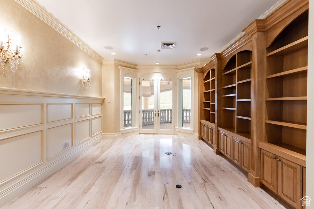 Interior space featuring french doors, ornamental molding, and light hardwood / wood-style flooring