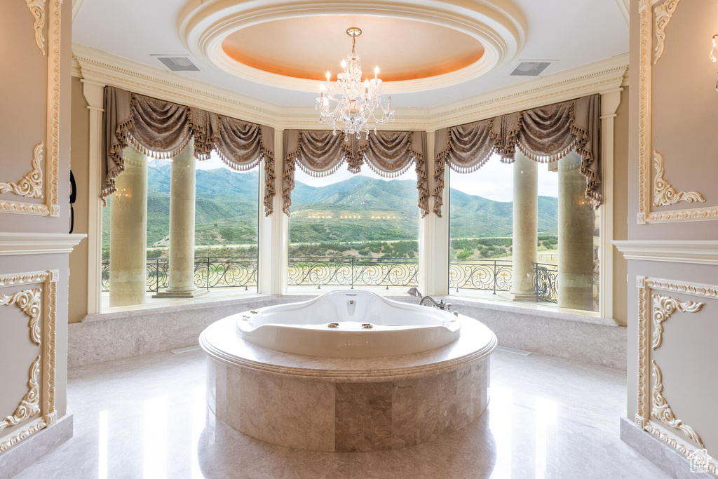 Bathroom featuring a wealth of natural light, a mountain view, and a tray ceiling