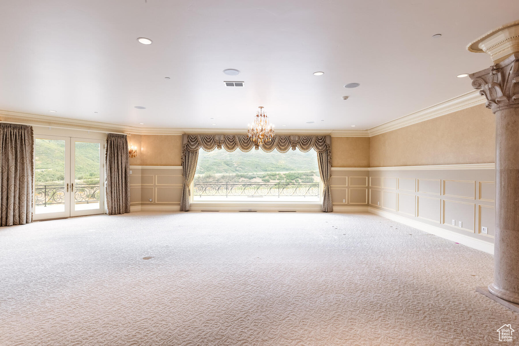 Interior space with a healthy amount of sunlight, a chandelier, french doors, and crown molding