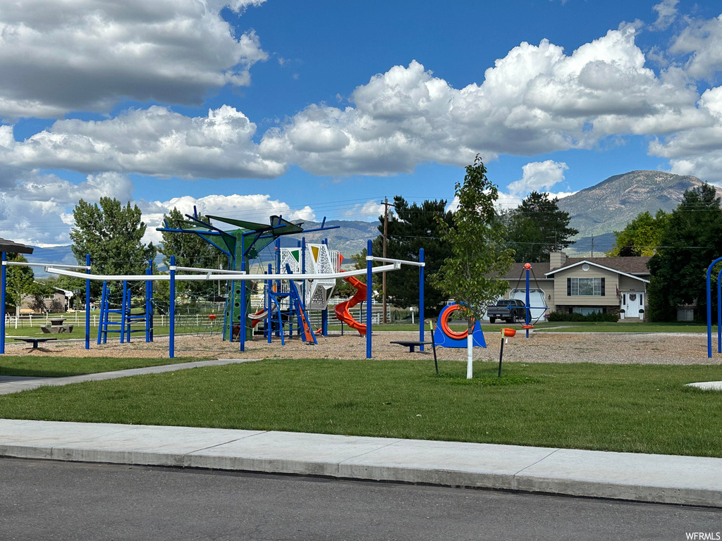 View of playground with a yard and a mountain view