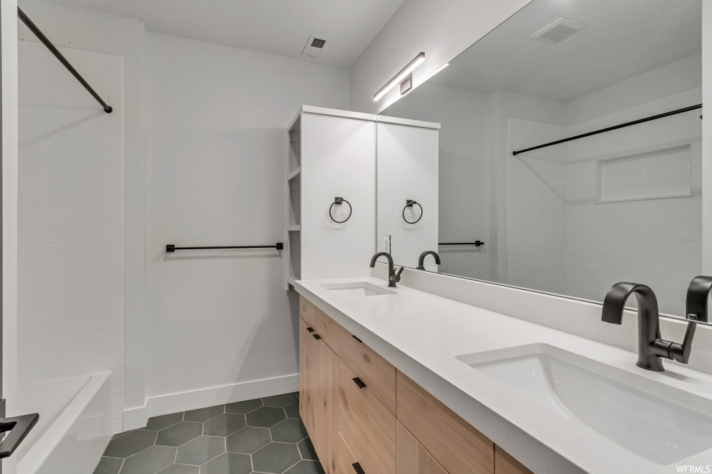 Bathroom featuring tile flooring, shower / washtub combination, and double vanity