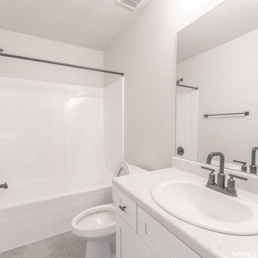 Full bathroom featuring tub / shower combination, vanity, mirror, and light tile floors
