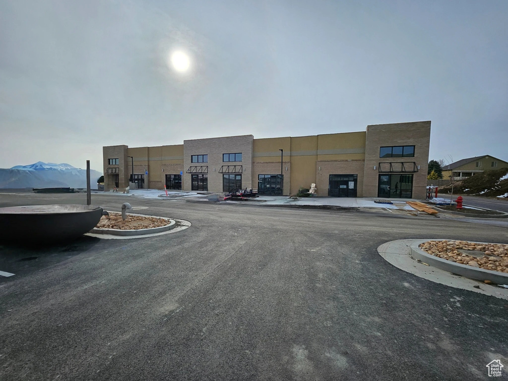 View of building exterior with uncovered parking and a mountain view