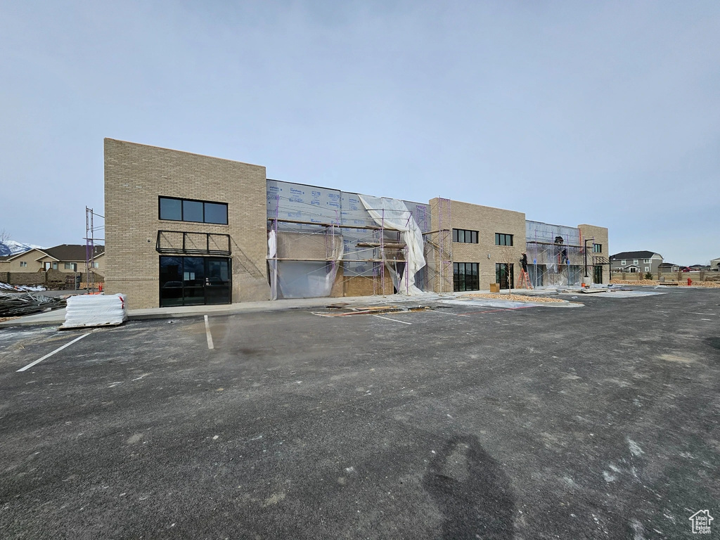 View of property featuring uncovered parking