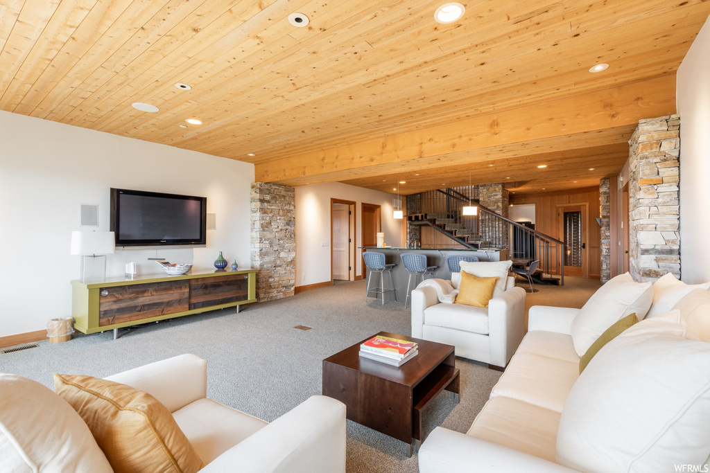 living room featuring carpet, a breakfast bar area, and TV