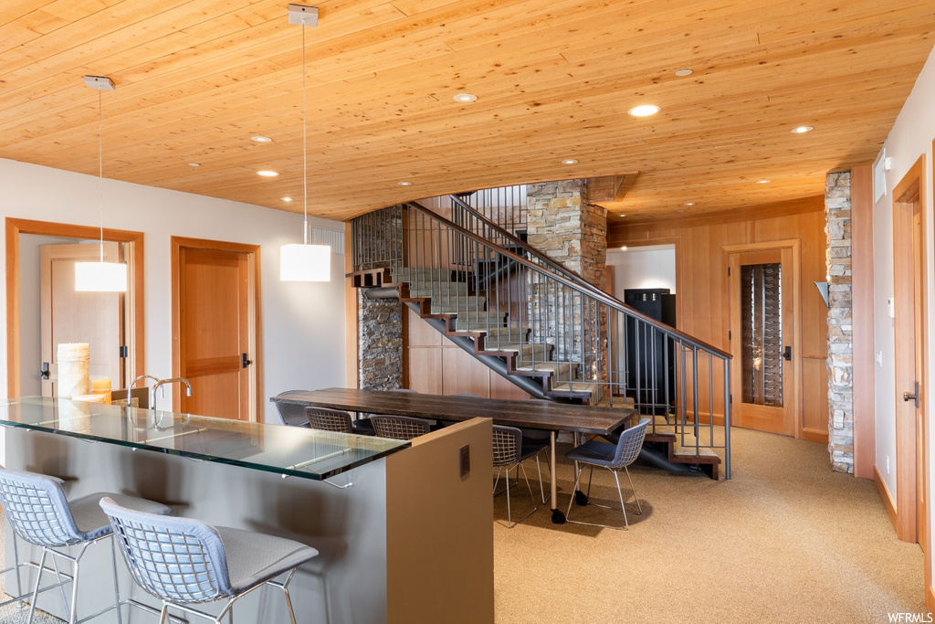 kitchen featuring a breakfast bar area, brown cabinetry, light flooring, and dark countertops