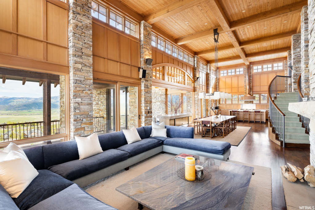hardwood floored living room featuring natural light and wood beam ceiling