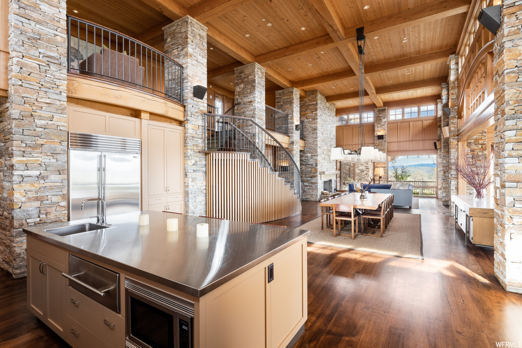 kitchen with a center island, refrigerator, microwave, dark parquet floors, and dark countertops