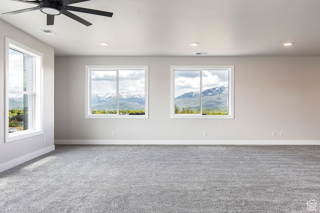 Unfurnished room with carpet, a mountain view, and ceiling fan