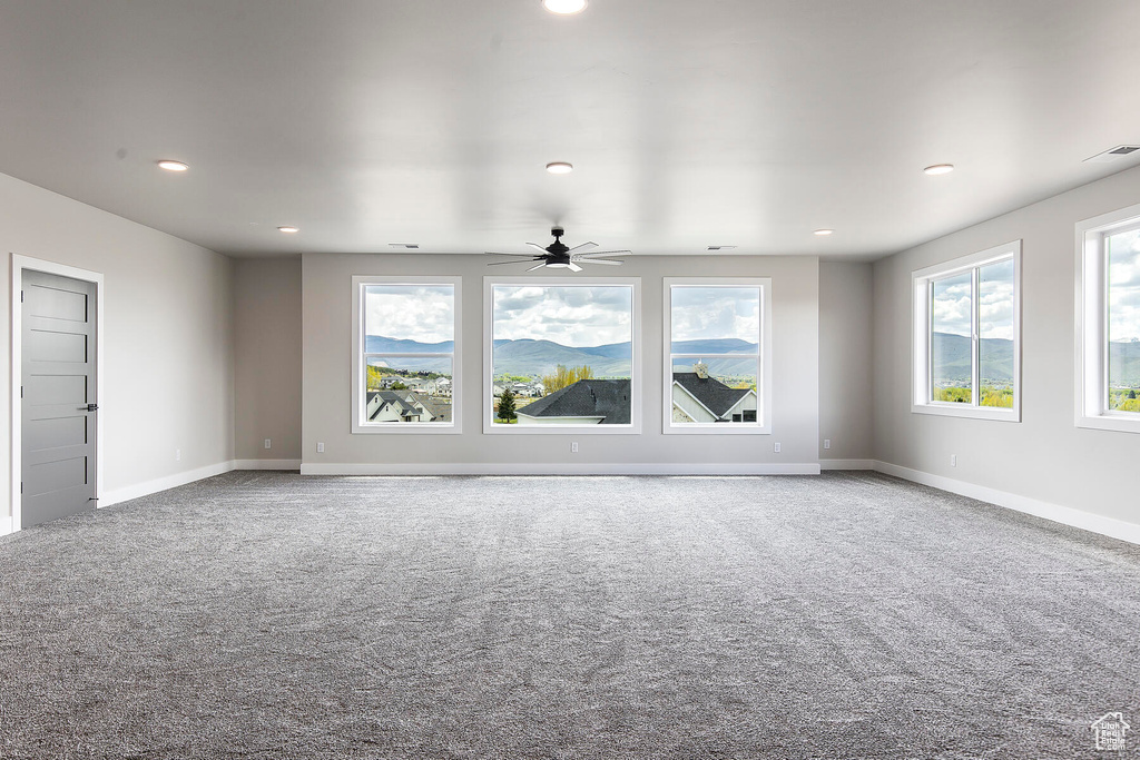 Unfurnished living room with carpet flooring and ceiling fan
