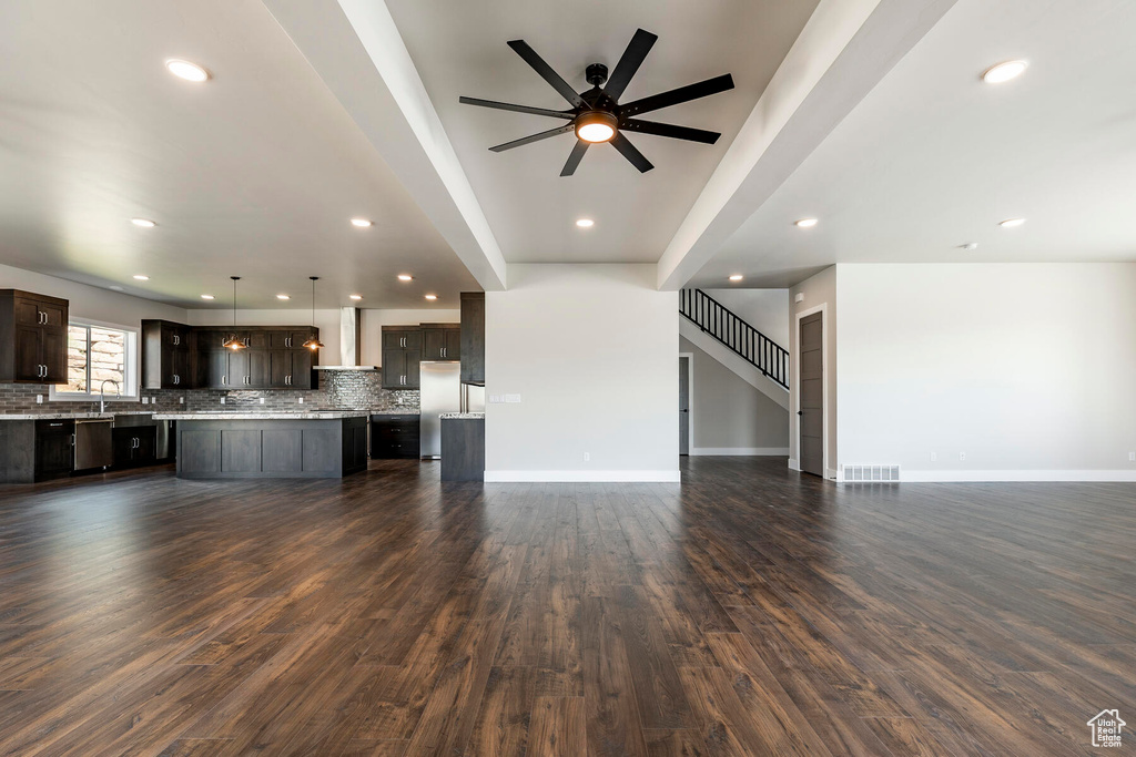 Unfurnished living room featuring sink, dark hardwood / wood-style flooring, and ceiling fan