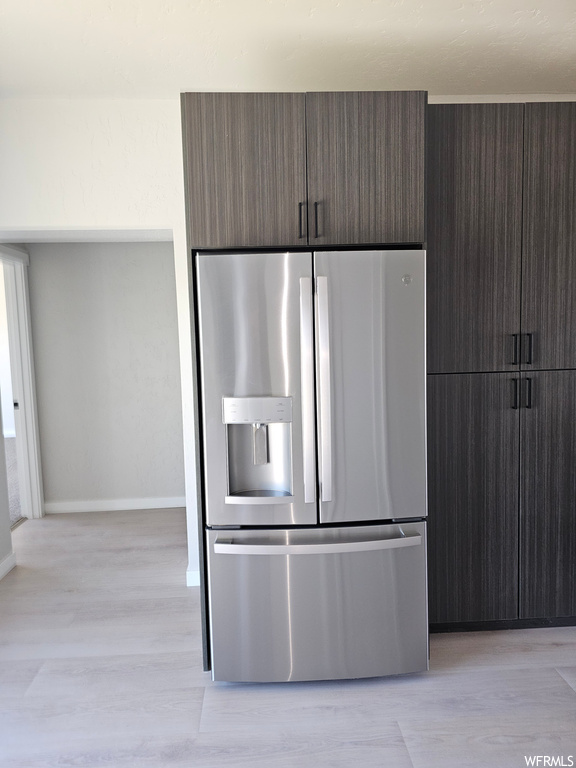 Kitchen featuring light hardwood flooring and stainless steel refrigerator with ice dispenser