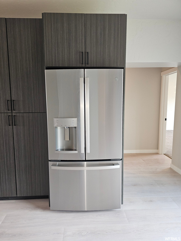 Kitchen featuring stainless steel fridge with ice dispenser and light hardwood flooring