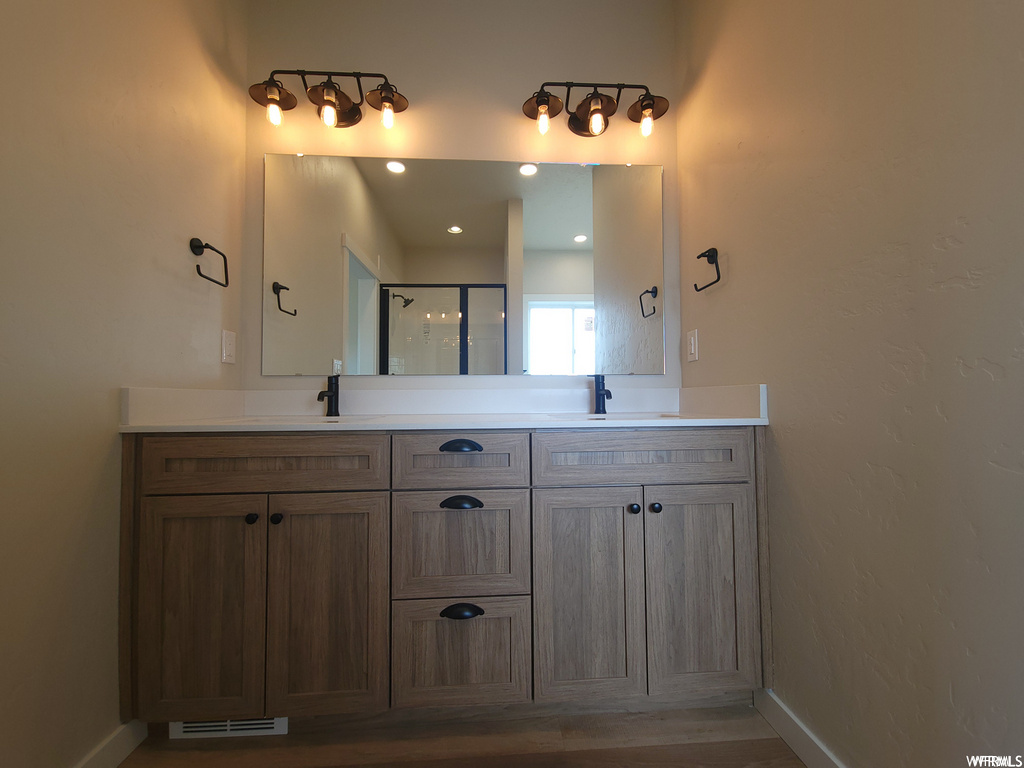 Bathroom featuring multiple mirrors, dual sinks, and dual large vanities