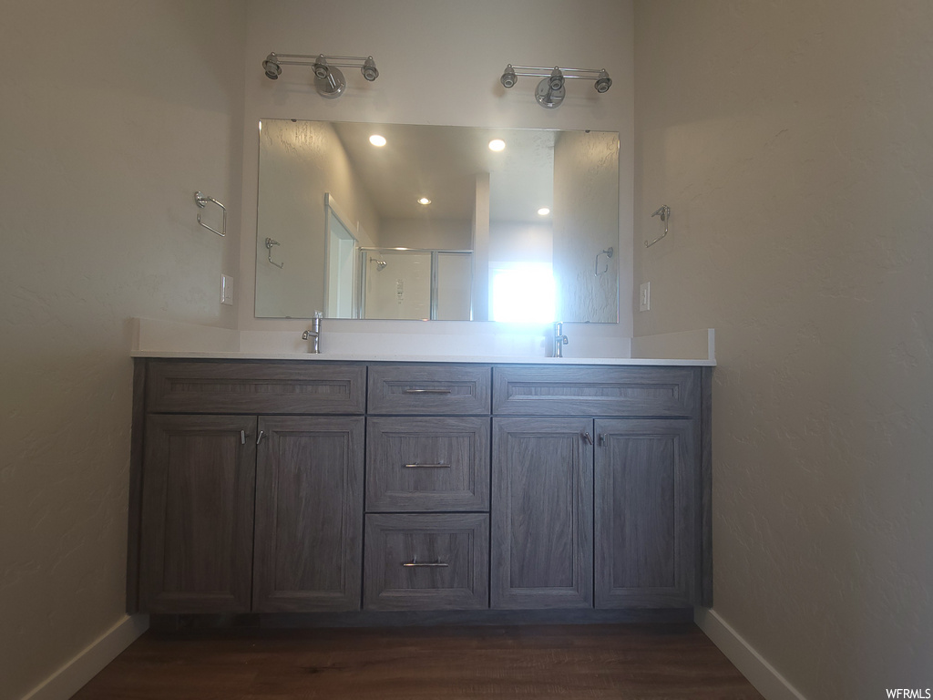 Bathroom featuring hardwood floors, mirror, and vanity