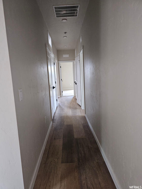 Corridor featuring dark hardwood floors