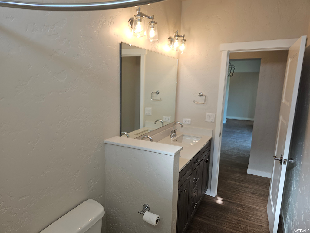 Bathroom featuring dark hardwood floors, mirror, and oversized vanity