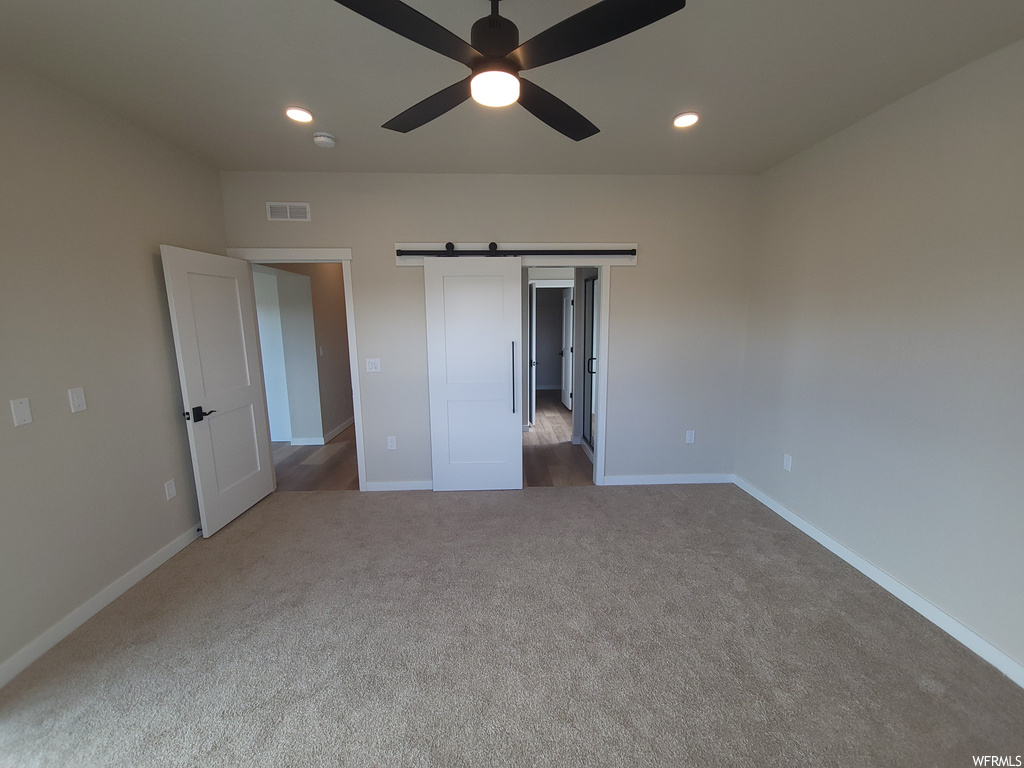 Carpeted bedroom with a ceiling fan