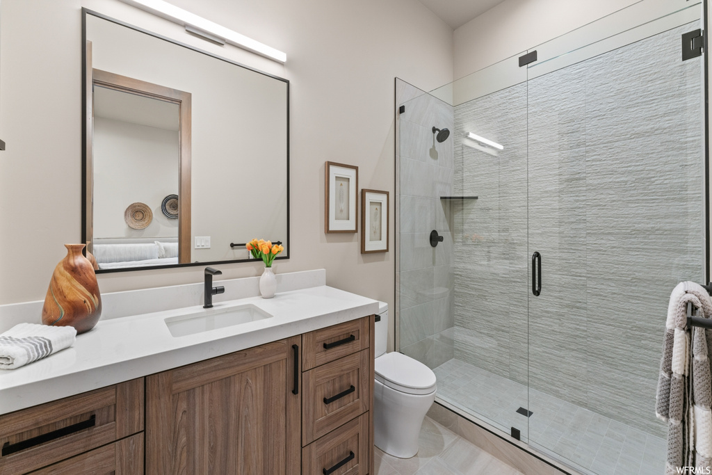 Bathroom with an enclosed shower, oversized vanity, light tile flooring, and mirror