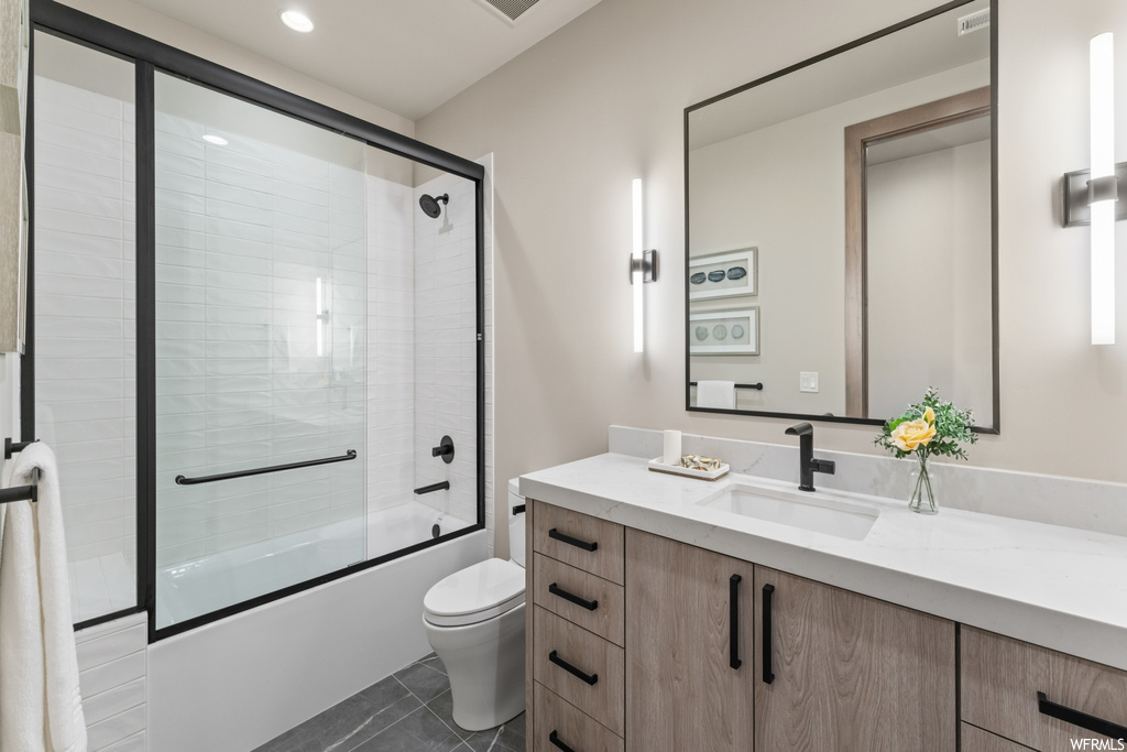Full bathroom featuring tile flooring, oversized vanity, mirror, and shower / bath combination with glass door