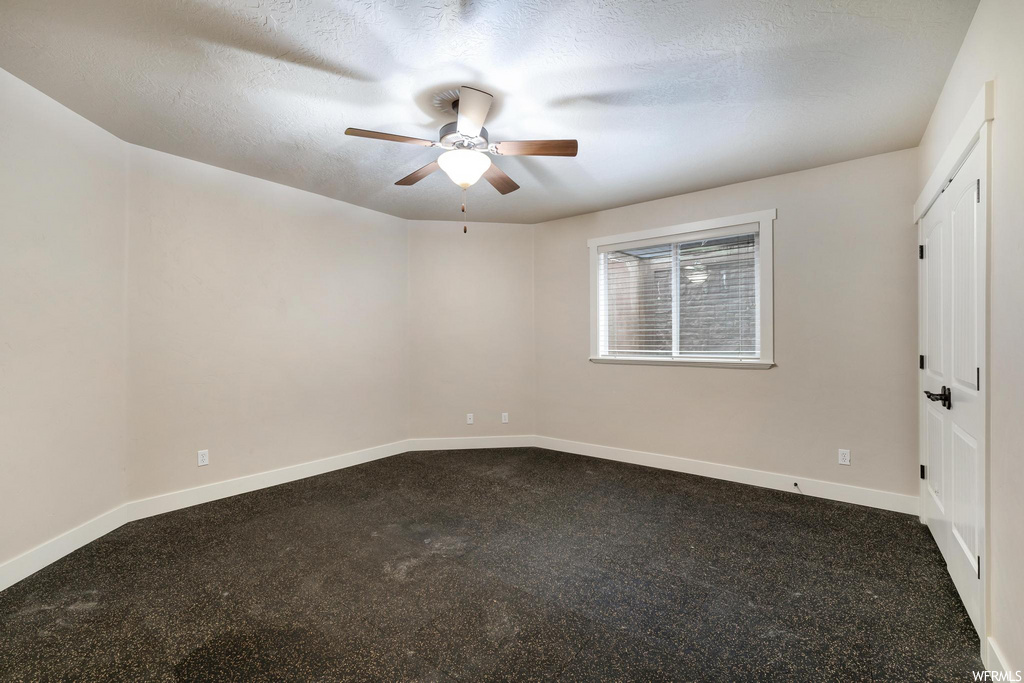 carpeted spare room featuring a ceiling fan