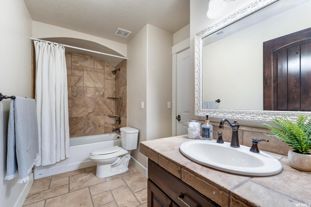 full bathroom with tile floors, toilet, shower / bathing tub combination, shower curtain, mirror, and vanity
