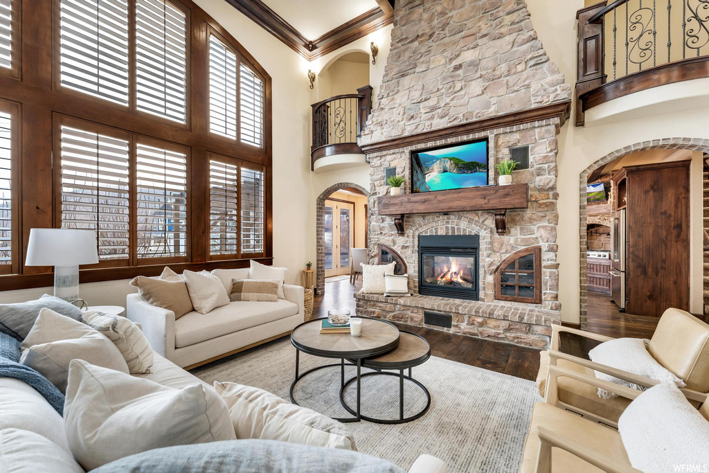 living room with a high ceiling, a fireplace, and hardwood floors
