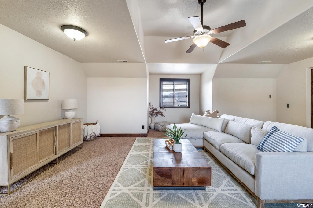 carpeted living room with a ceiling fan and natural light