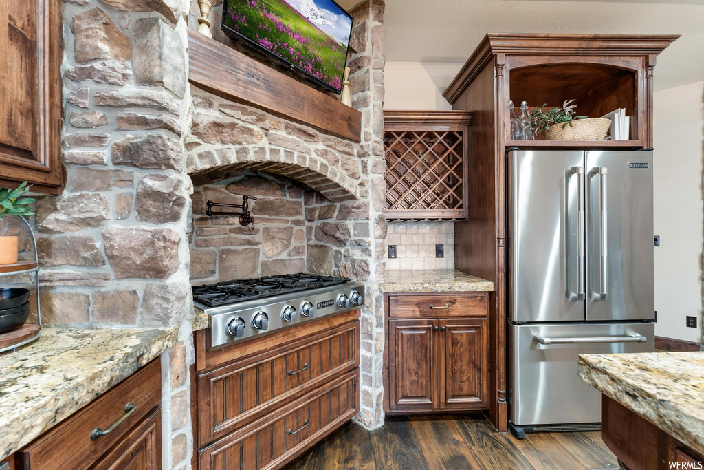 kitchen featuring gas cooktop, stainless steel refrigerator, light stone countertops, and dark hardwood floors