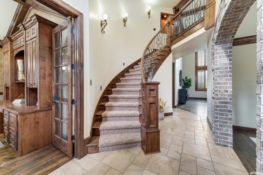 stairway with tile floors and exposed bricks