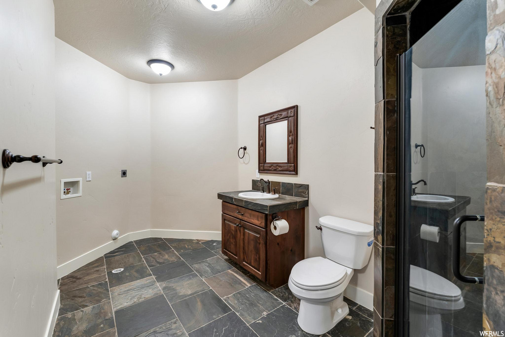 half bathroom featuring tile floors, mirror, toilet, and vanity