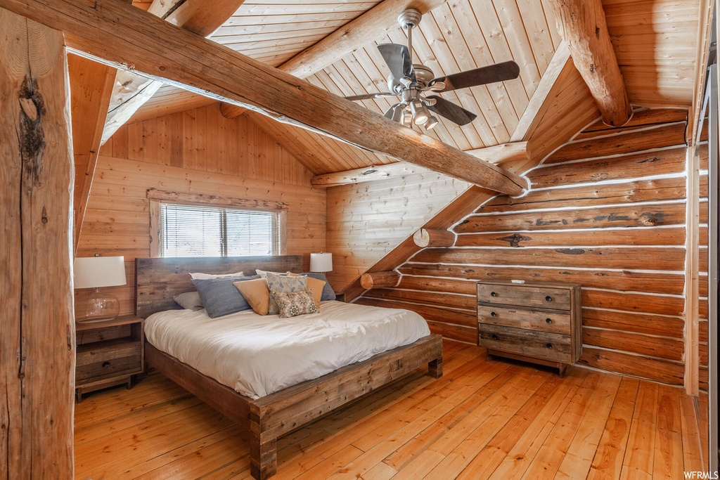 Bedroom featuring lofted ceiling with beams, light hardwood / wood-style flooring, and wood ceiling