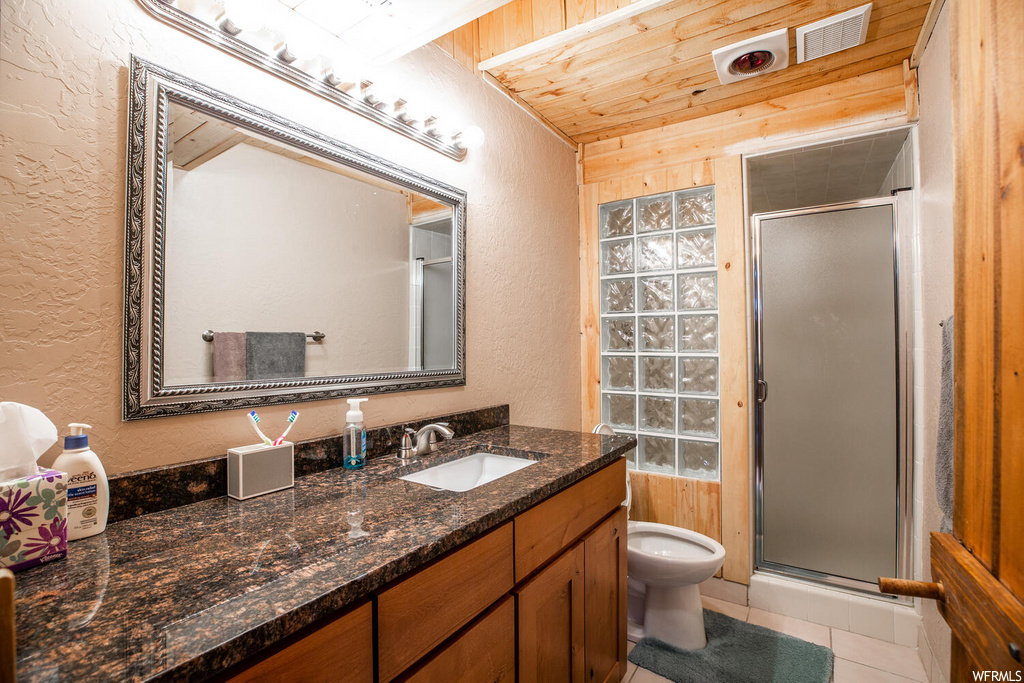 Bathroom featuring wood walls, an enclosed shower, wooden ceiling, large vanity, and toilet