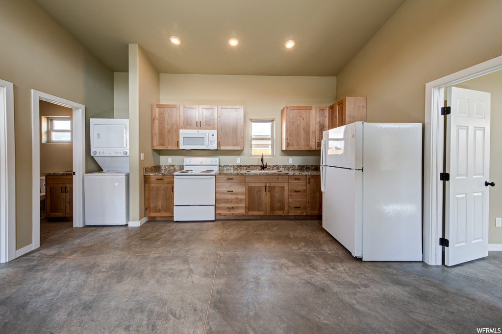 kitchen with natural light, refrigerator, microwave, washer / dryer, electric range oven, and dark floors