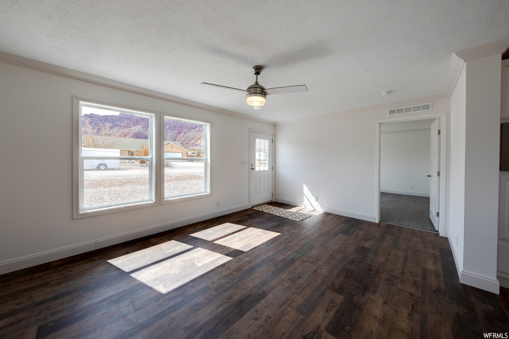 spare room featuring natural light, wood-type flooring, and a ceiling fan