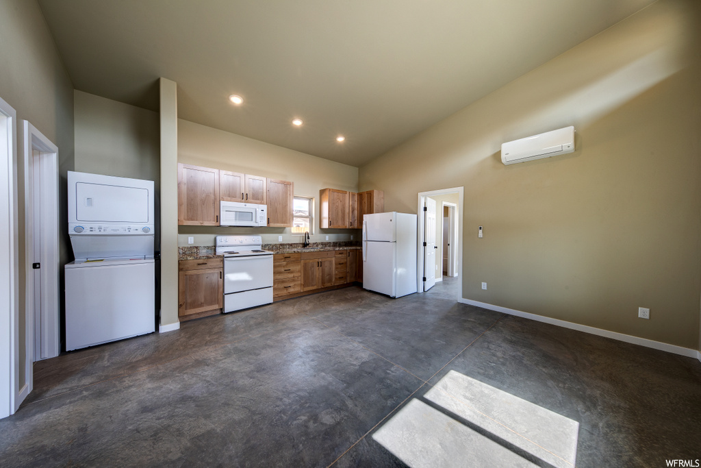 kitchen with natural light, range oven, washer / dryer, refrigerator, microwave, and dark tile flooring
