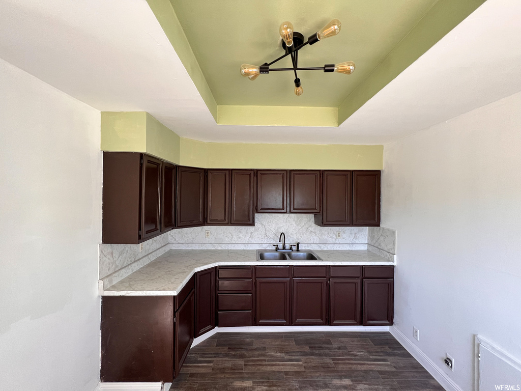 Kitchen featuring dark brown cabinets, dark hardwood floors, and light countertops