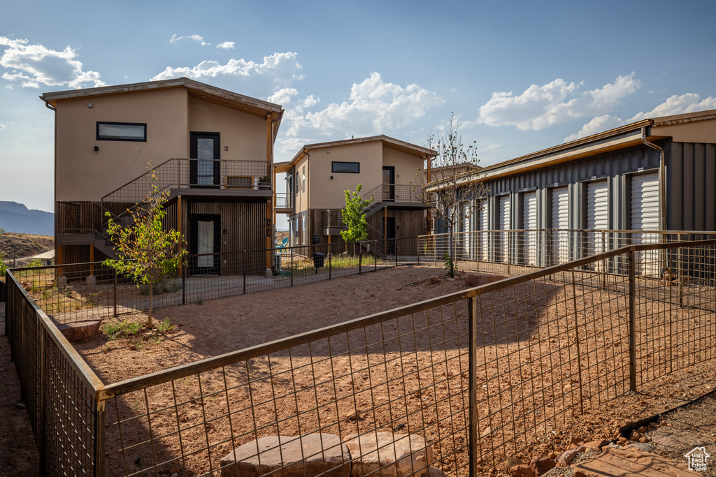 View of front of property featuring stucco siding and a fenced backyard