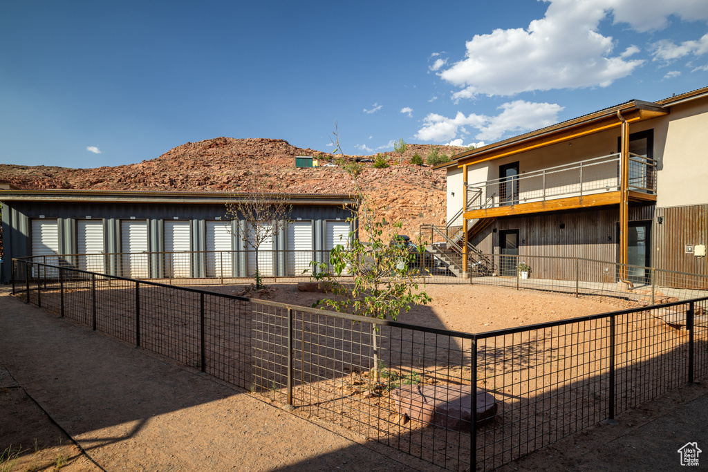 Rear view of property featuring stairs, a fenced backyard, and stucco siding