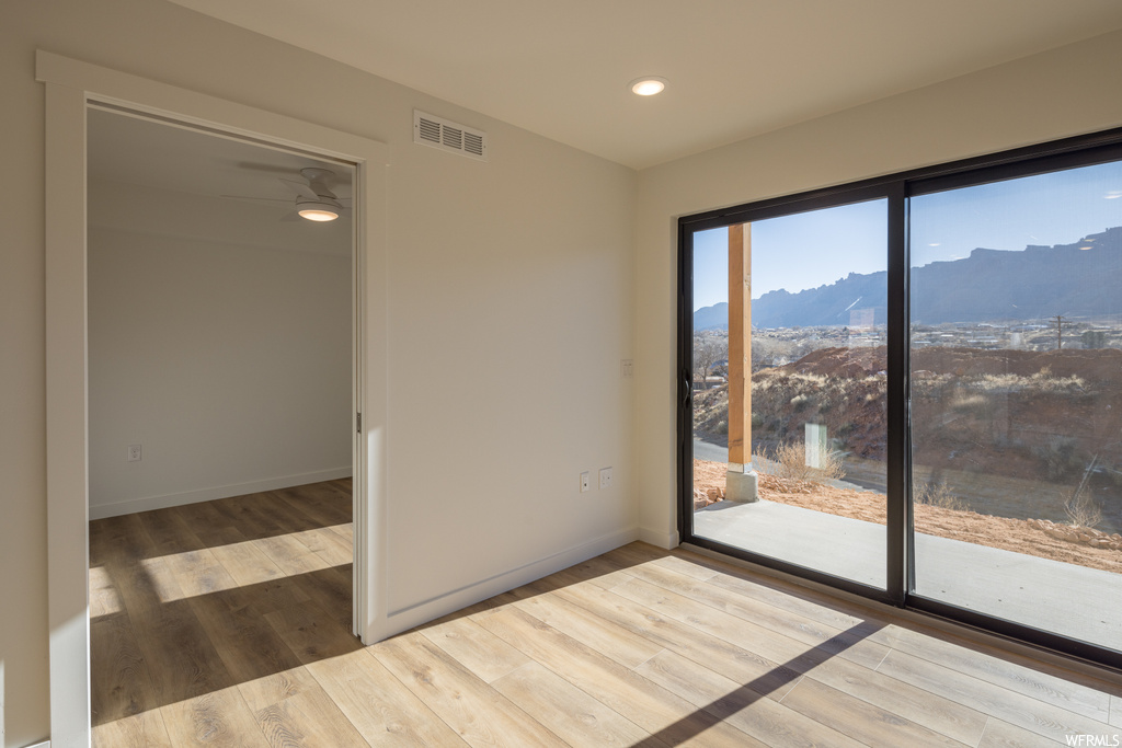 Unfurnished room featuring ceiling fan, a mountain view, and hardwood / wood-style flooring