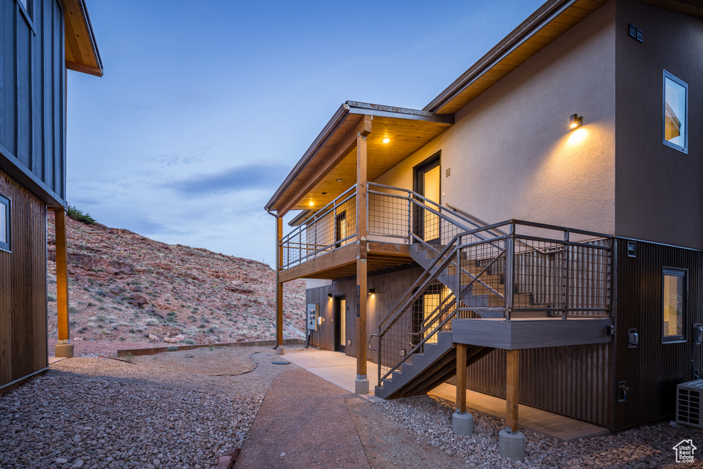 View of home's exterior featuring stairway, stucco siding, a mountain view, and a balcony