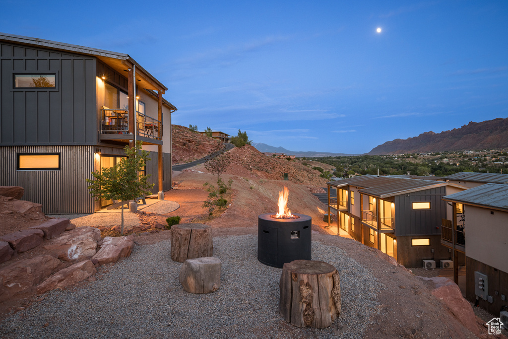 View of patio with an outdoor fire pit, a balcony, and a mountain view