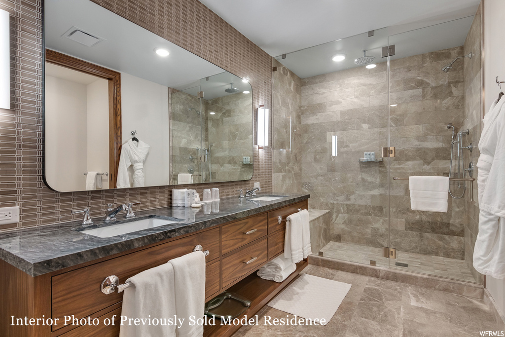 bathroom featuring tile floors, multiple mirrors, shower cabin, and dual large vanity