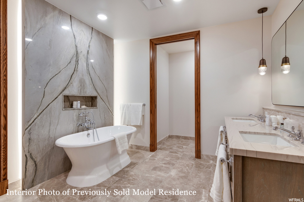 bathroom featuring tile flooring, a bathtub, mirror, and double large vanity