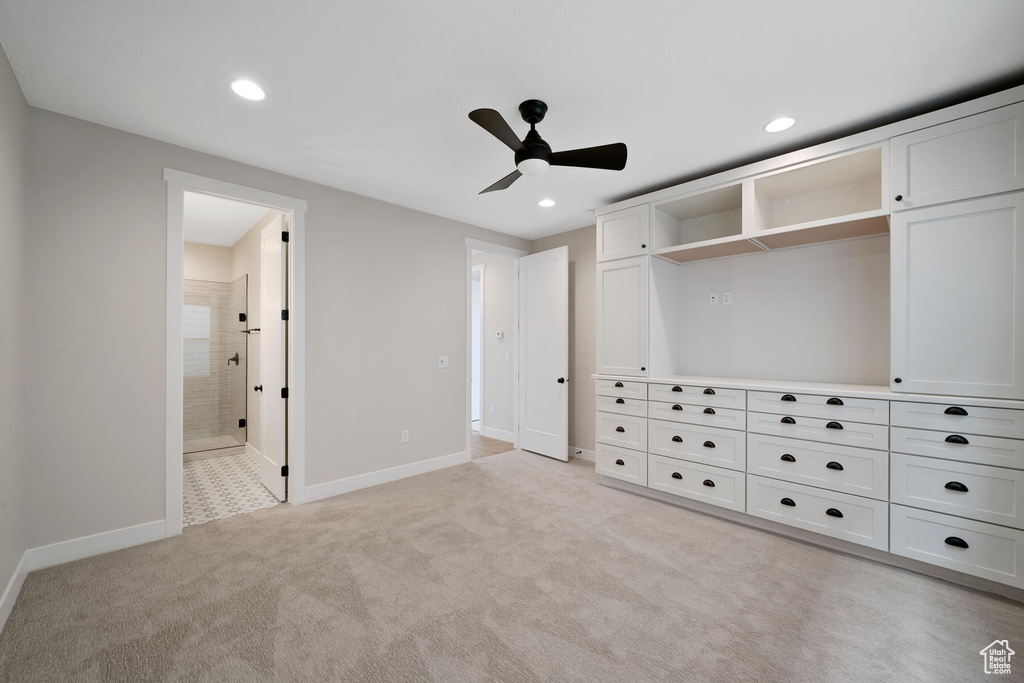 Unfurnished bedroom with a closet, ceiling fan, ensuite bath, and light colored carpet